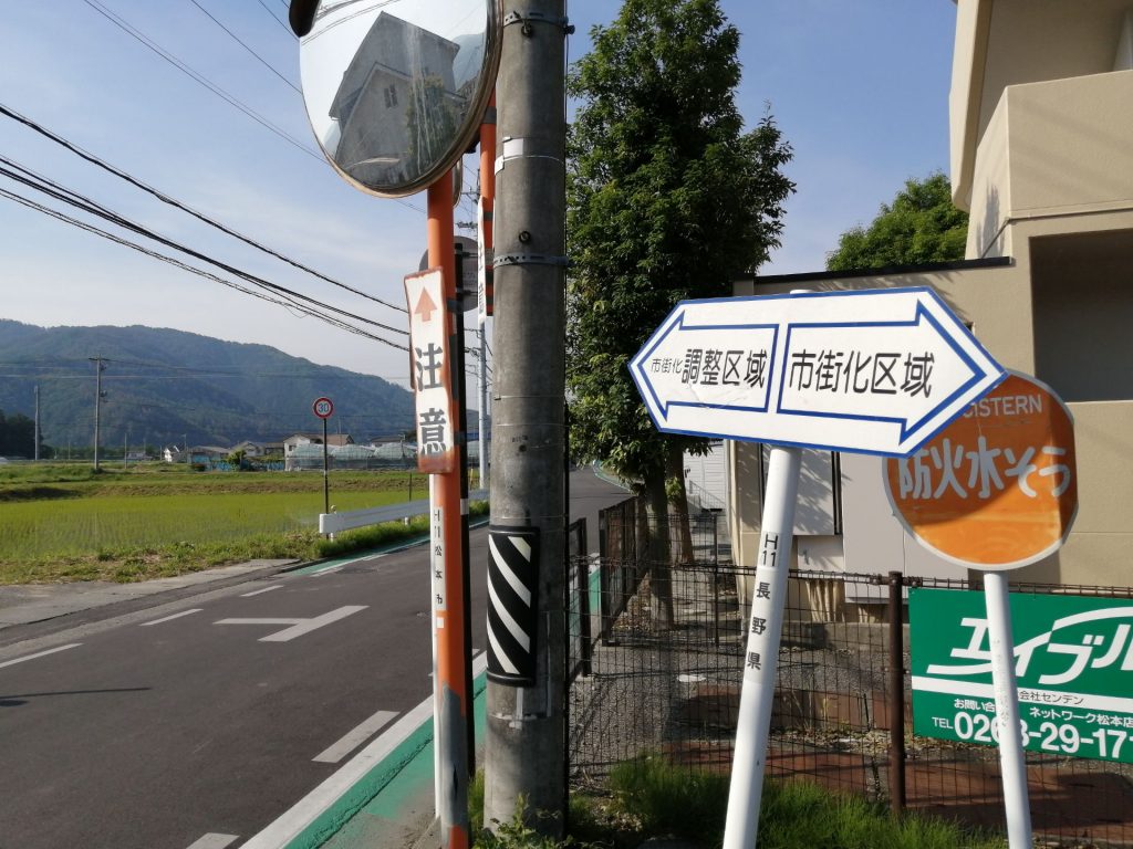 松本市里山辺に立つ「調整区域」と「市街化区域」を示す看板